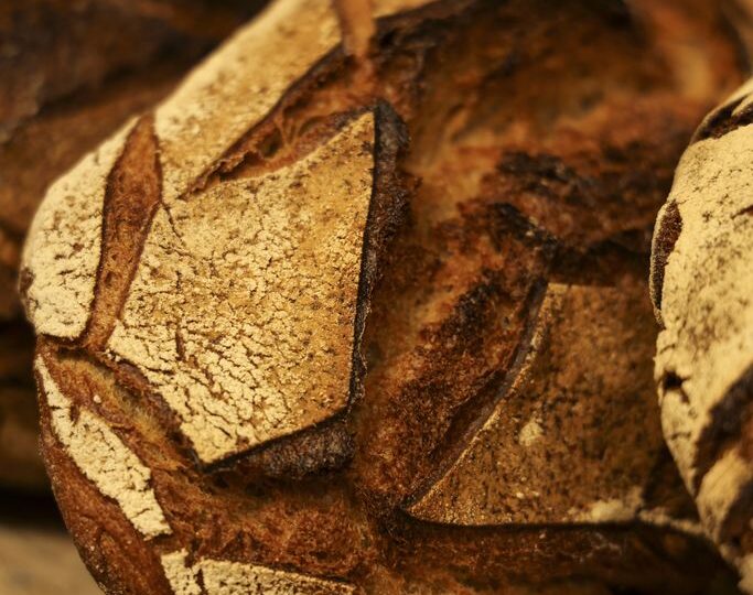 Une miche de pain de campagne à la croûte scarifiée, posée sur un plan de travail